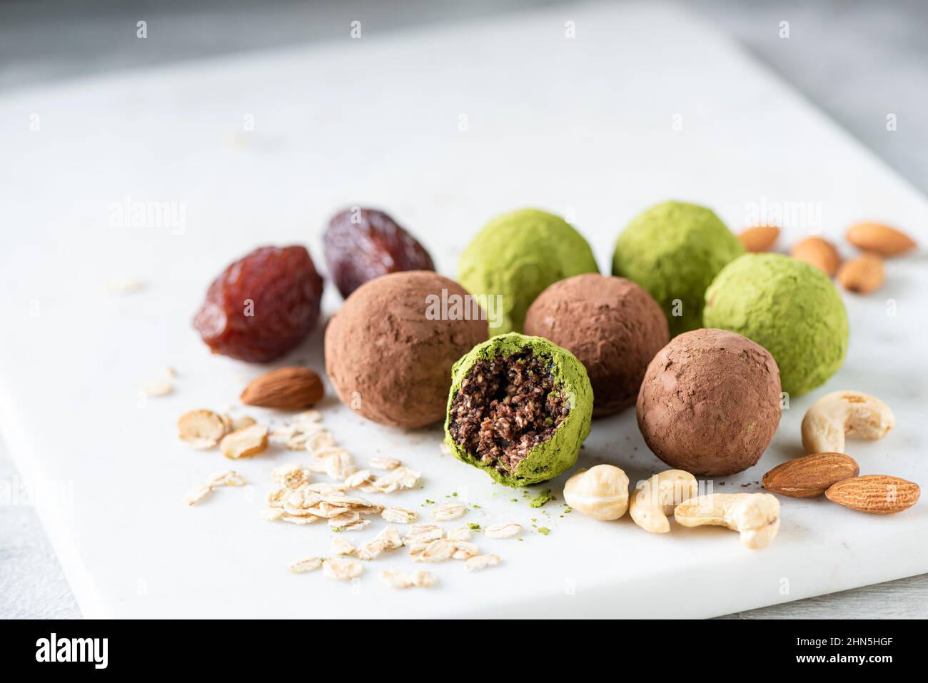 Sfere di energia sana con datteri e noci rivestite con polvere di matcha di  tè verde. Tartufi vegani senza zucchero Foto stock - Alamy