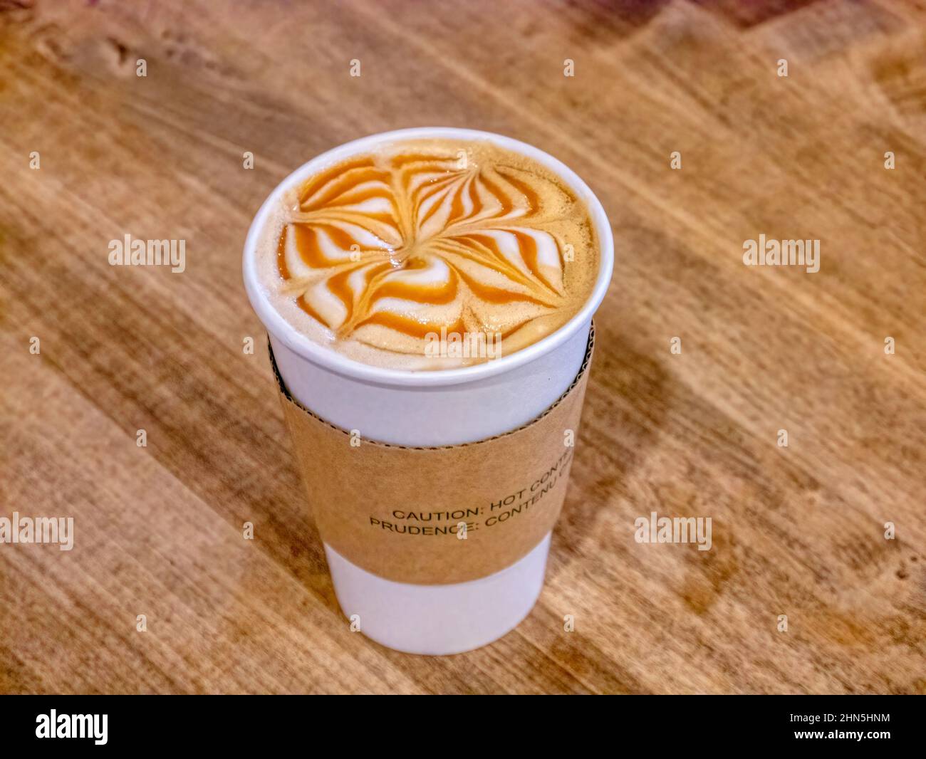 Tappo medio di cappuccino al caramello su tavola in legno Foto Stock