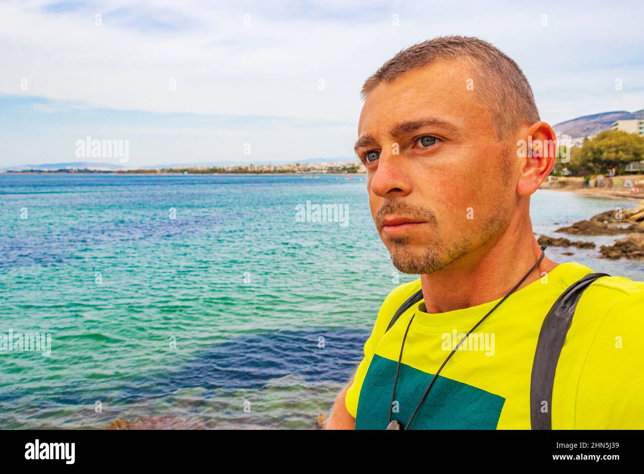 Modello di turista in spiaggia naturale turchese verde e acqua a Vouliagmeni Kavouri Beach vicino a Voula in Grecia. Foto Stock