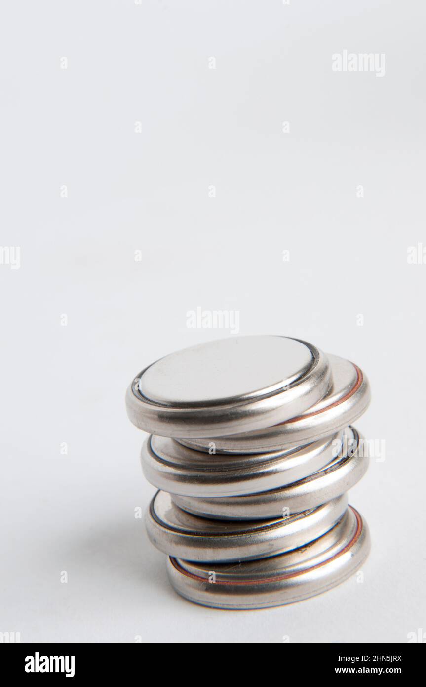 Scatto verticale delle batterie a bottone su sfondo semplice Foto Stock