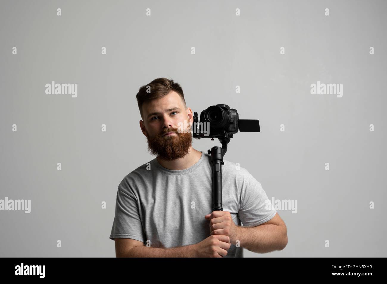 Filmmaking, hobby e concetto di creatività. Directop professionale maschile della fotografia, video di ripresa cameraman utilizzando la moderna fotocamera reflex digitale su 3 assi Foto Stock