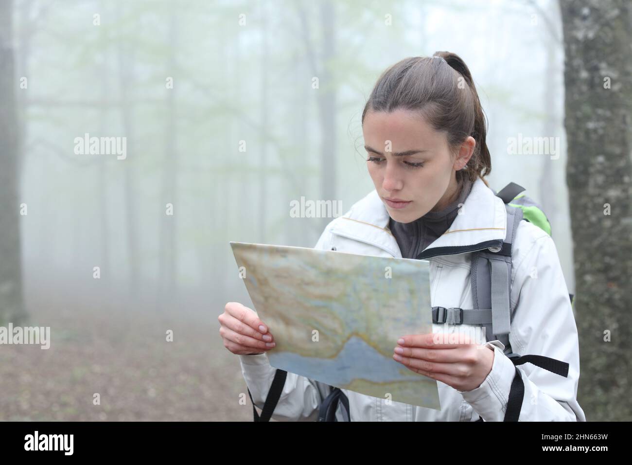 Trekker serio controllare carta mappa per trovare la posizione in una foresta Foto Stock