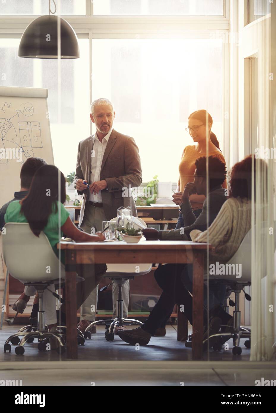 Condividere il suo acume aziendale. Shot di un gruppo di colleghi in una riunione della sala riunioni. Foto Stock