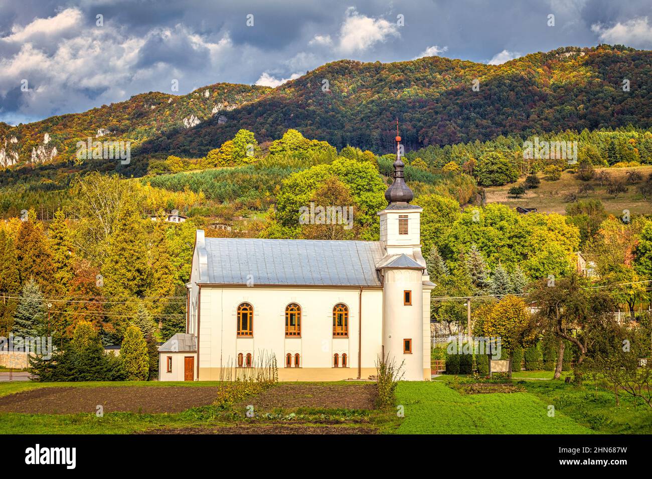 Chiesa a Sulov - Hradna con sfondo di rocce di Sulov in autunno, Slovacchia, Europa. Foto Stock