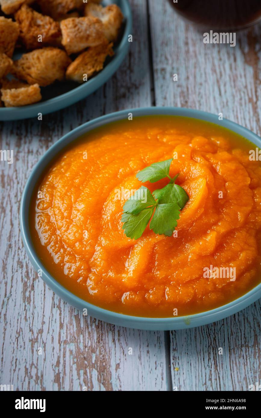 Ciotola di zuppa di zucca con crostini di formaggio e prezzemolo Foto Stock