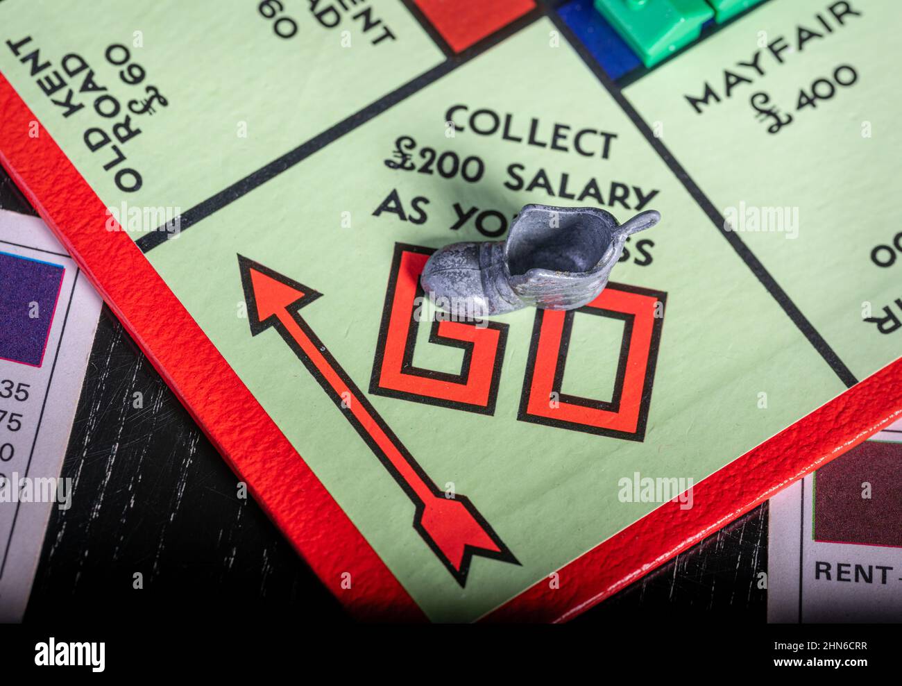 Il vecchio token di boot che passa Go su un Monopoly Board Foto Stock Il vecchio token di boot che passa Go su un Monopoly Board Foto Stock