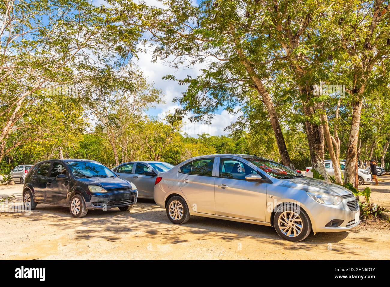 Parcheggio con auto e strada percorso ghiaia nella giungla e natura tropicale a Kaan Luum laguna Tulum Quintana Roo Messico. Foto Stock