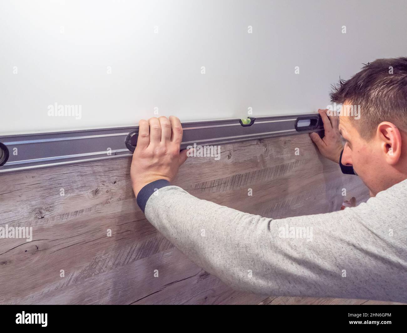 caen, francia febbraio 2022. Un falegname controlla il livello con una livella a bolla d'aria nel banco della cucina. Assemblaggio di mobili professionali in cucina Foto Stock