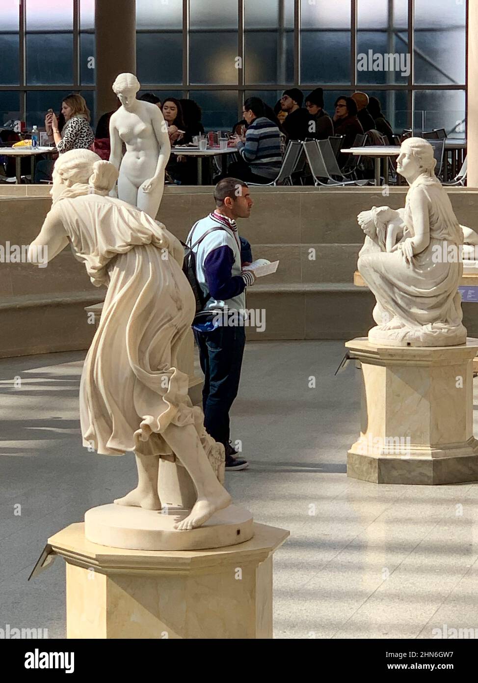 Maschio visitatore che studia scultura in American Wing, Met Museum Foto Stock