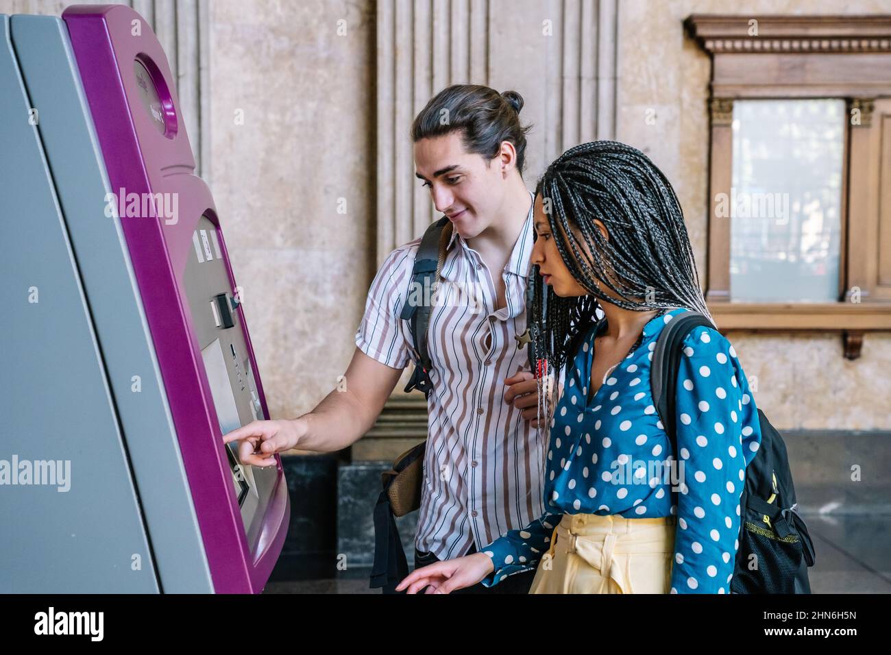 Diverse coppie che acquistano biglietti dalla macchina automatica Foto Stock