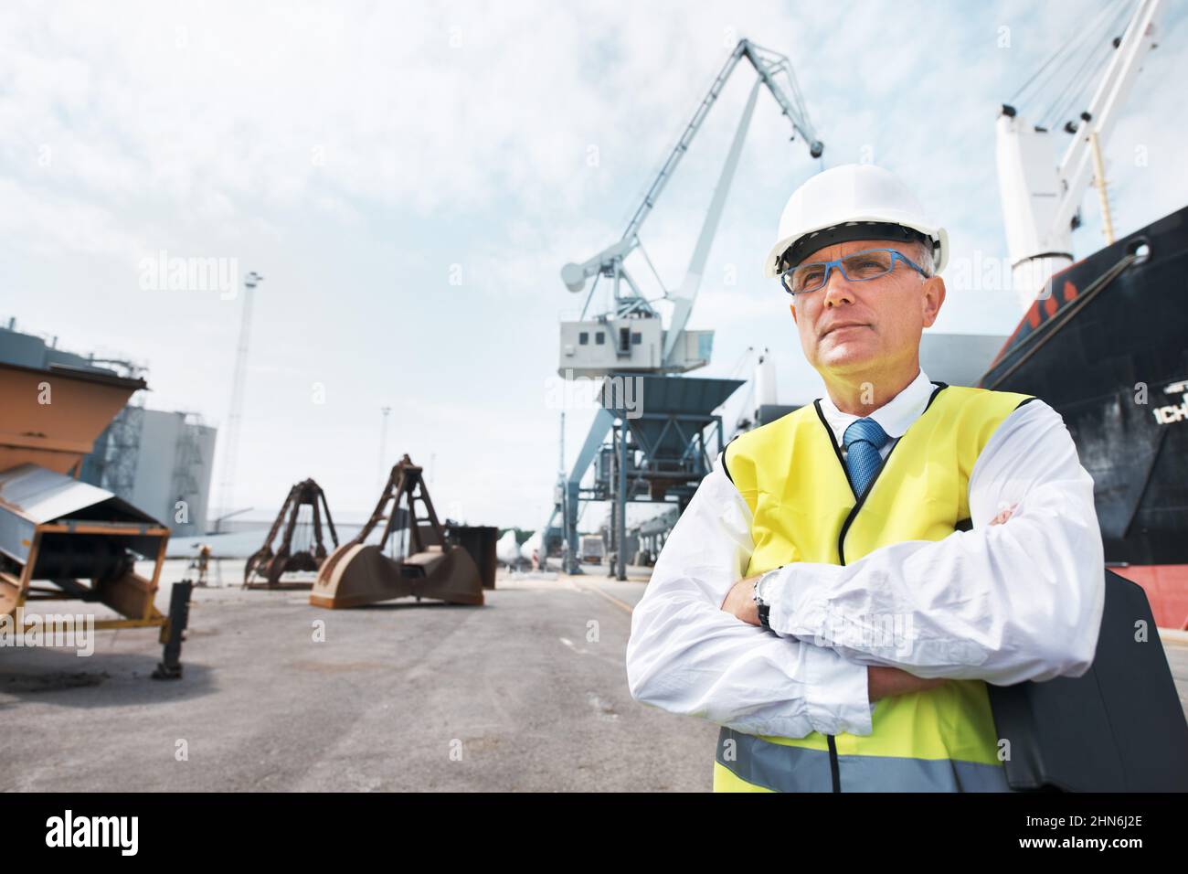 Ho la mia attività e sono orgoglioso. Ritratto di un lavoratore portuale in piedi al porto in mezzo all'attività dell'industria marittima. Foto Stock