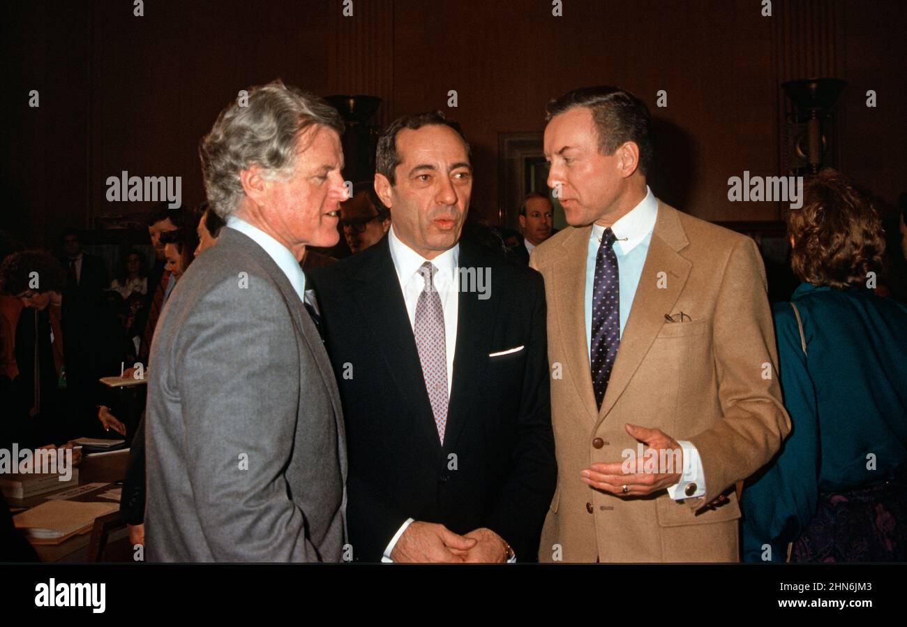 Il governatore Mario Cuomo (democratico di New York), Center, parla con il senatore degli Stati Uniti Edward M. “Ted” Kennedy (democratico del Massachusetts), il senatore di sinistra e gli Stati Uniti Orrin Hatch (repubblicano dello Utah), di destra, prima di dare testimonianza dinanzi al Comitato del lavoro e delle risorse umane del Senato degli Stati Uniti su Capitol Hill a Washington, DC il 23 febbraio 1988. Credit: Arnie Sachs/CNP Foto Stock