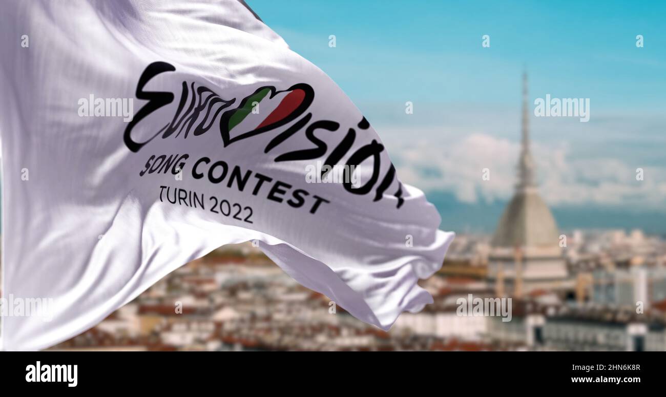 Torino, Italia, Gennaio 2022: La bandiera bianca con il logo Eurovisione Song Contest 2022 che ondola nel vento con il paesaggio sfocato di Torino. Foto Stock