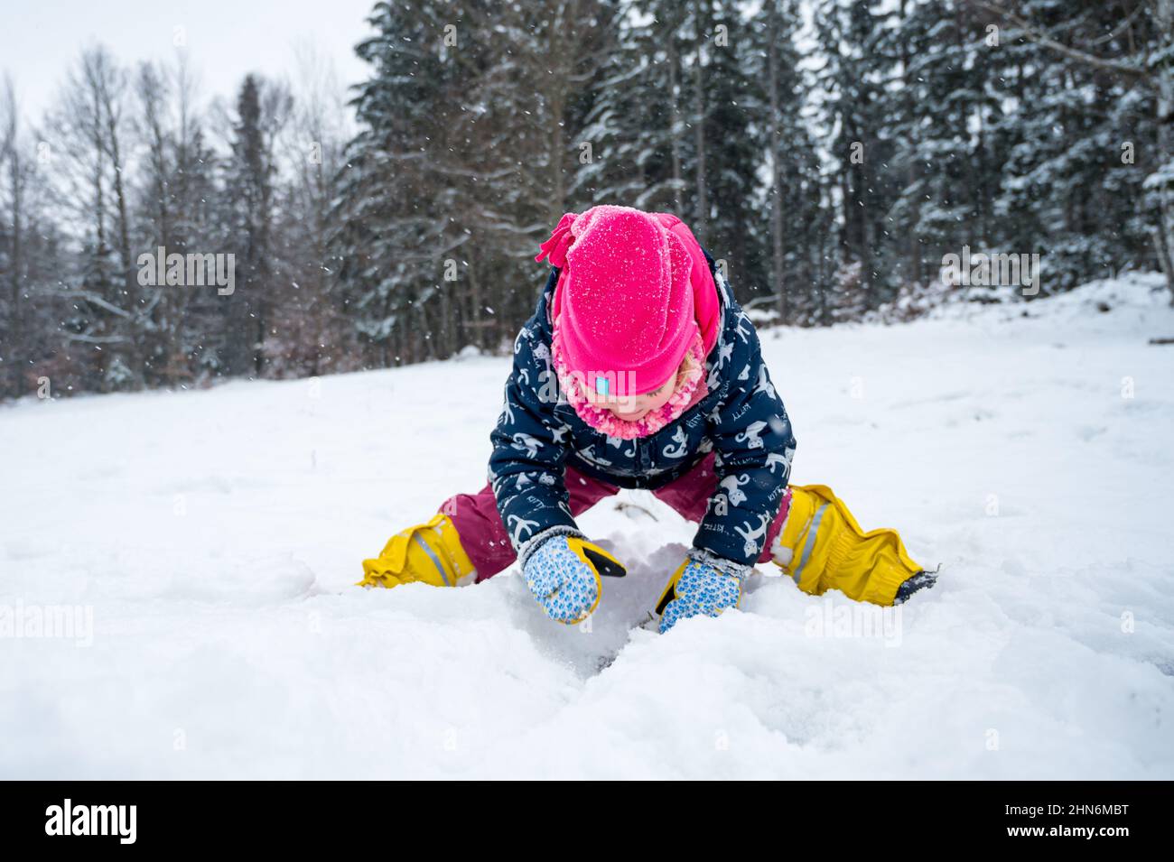 Ritratto di una ragazza carina che gioca con la neve al mattino freddo. Foto Stock