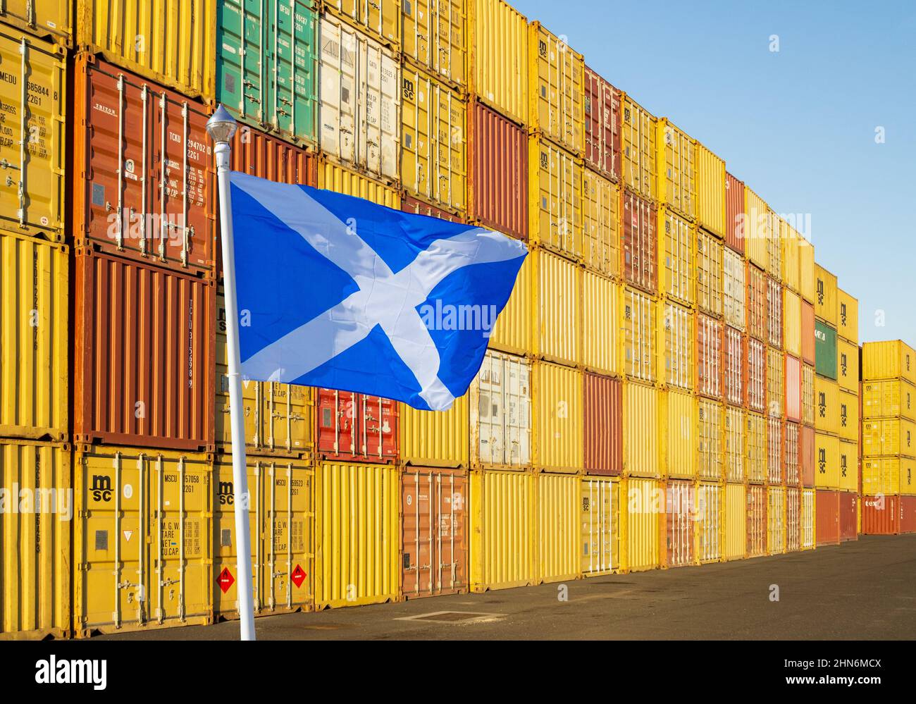 Bandiera della Scozia con contenitori impilati in background. Freeport, Freeport, Brexit, import, export, economia, commercio... concetto Foto Stock