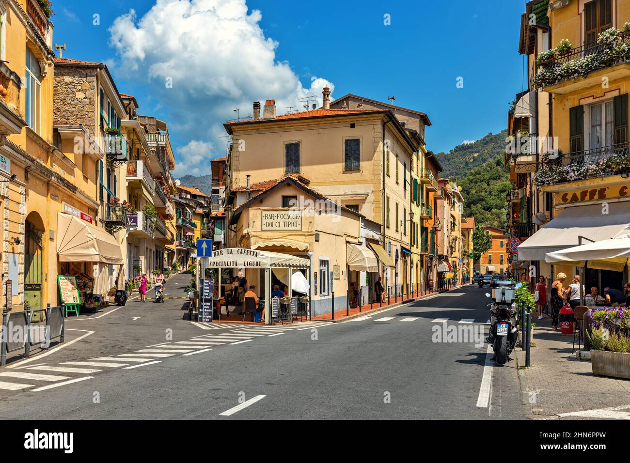Strade tra vecchie case con caffè all'aperto e ristoranti a Dolceacqua - piccola città in Italia. Foto Stock
