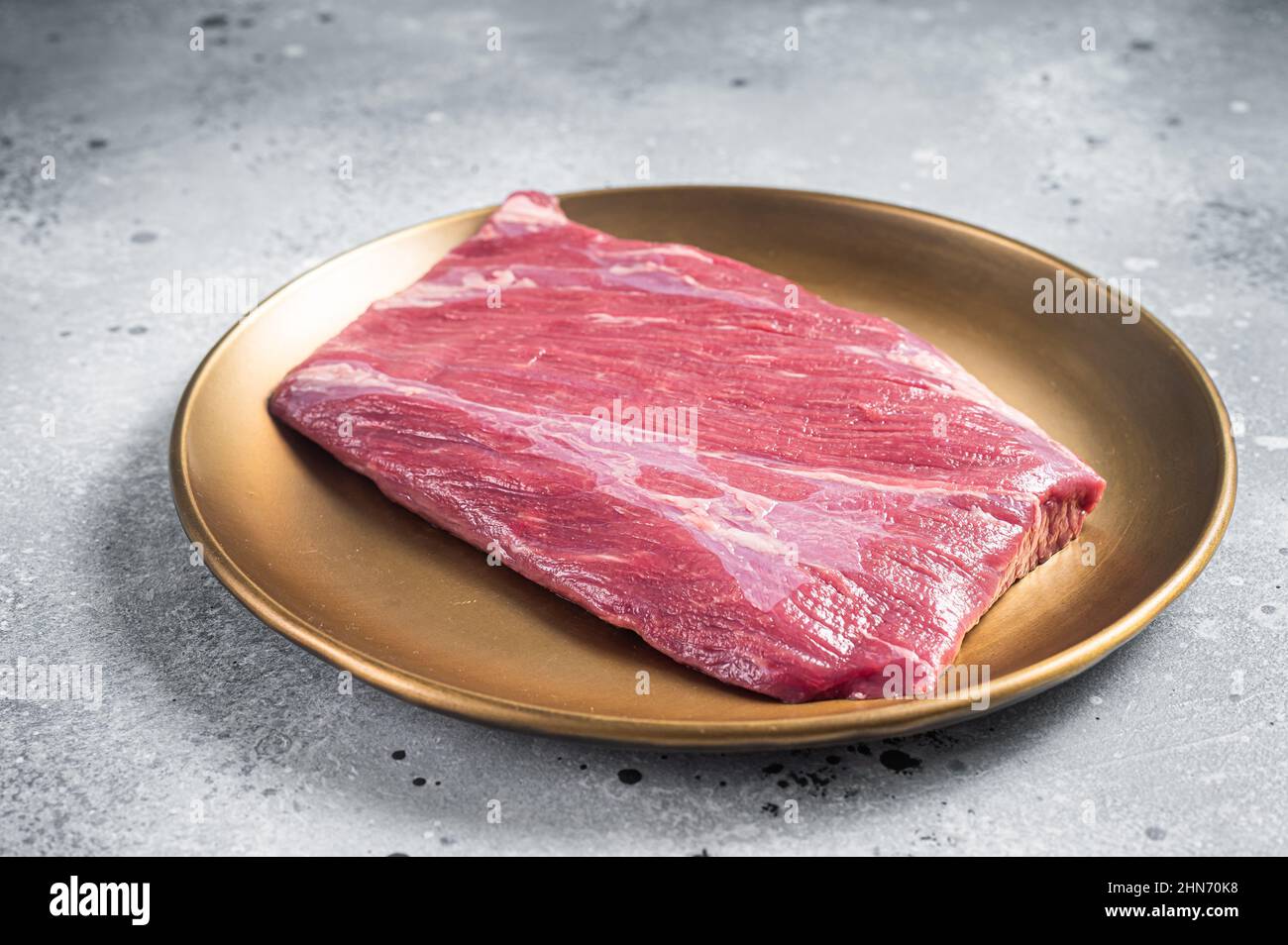 Manzo crudo sul fianco bistecca di carne marmorizzata sul tavolo del macellaio. Sfondo grigio. Vista dall'alto Foto Stock