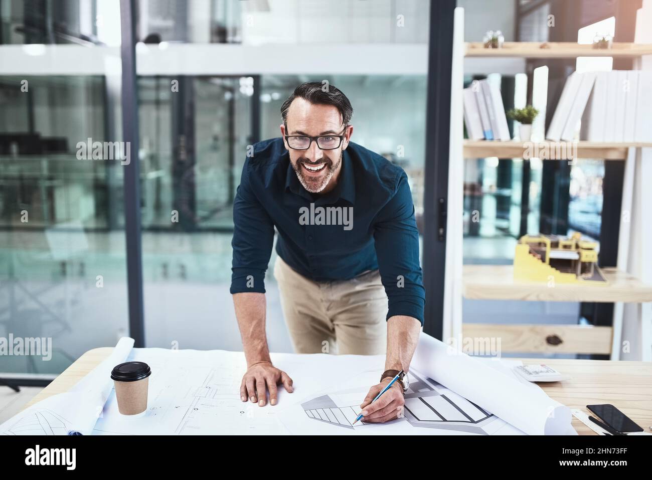 Non vedo l'ora di iniziare a costruire. Scatto di un architetto maschile maturo che lavora su un progetto nel suo ufficio. Foto Stock