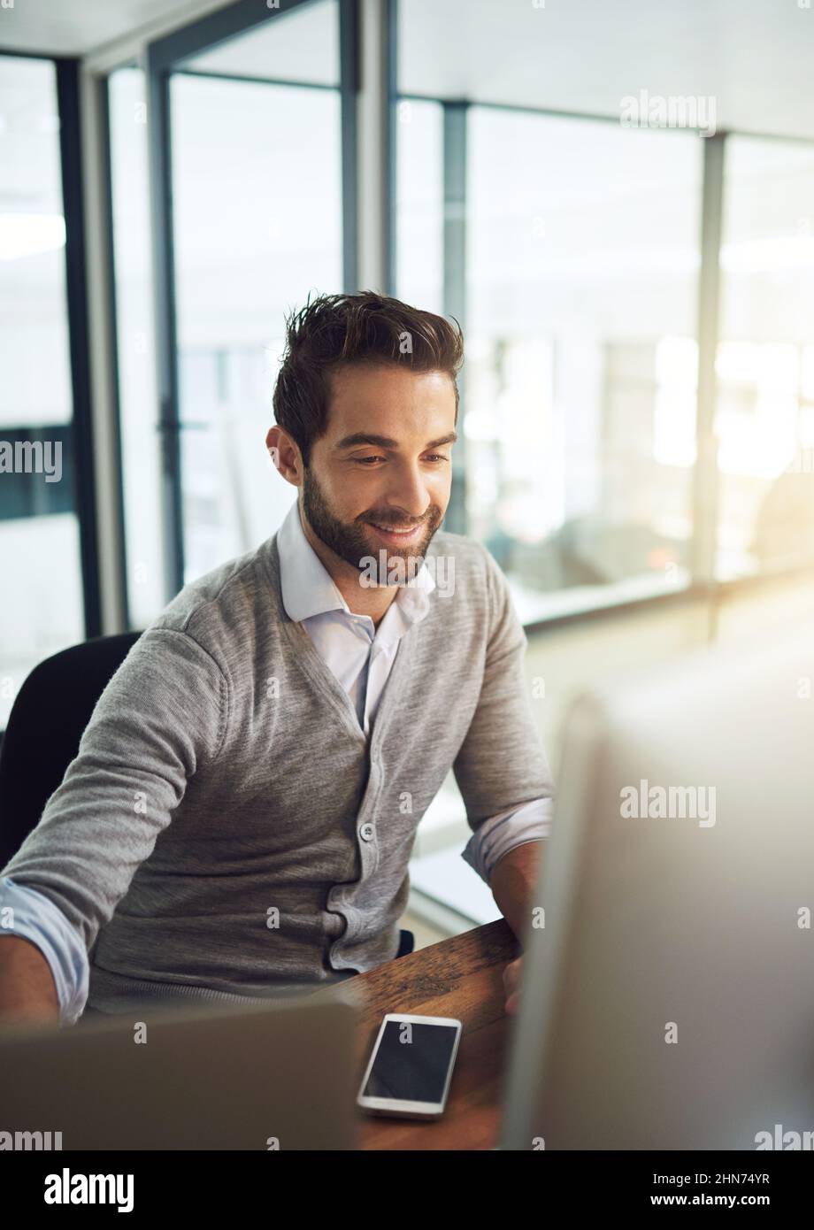 Egli rimane in cima al suo lavoro. Scatto corto di un uomo d'affari che lavora nel suo ufficio. Foto Stock