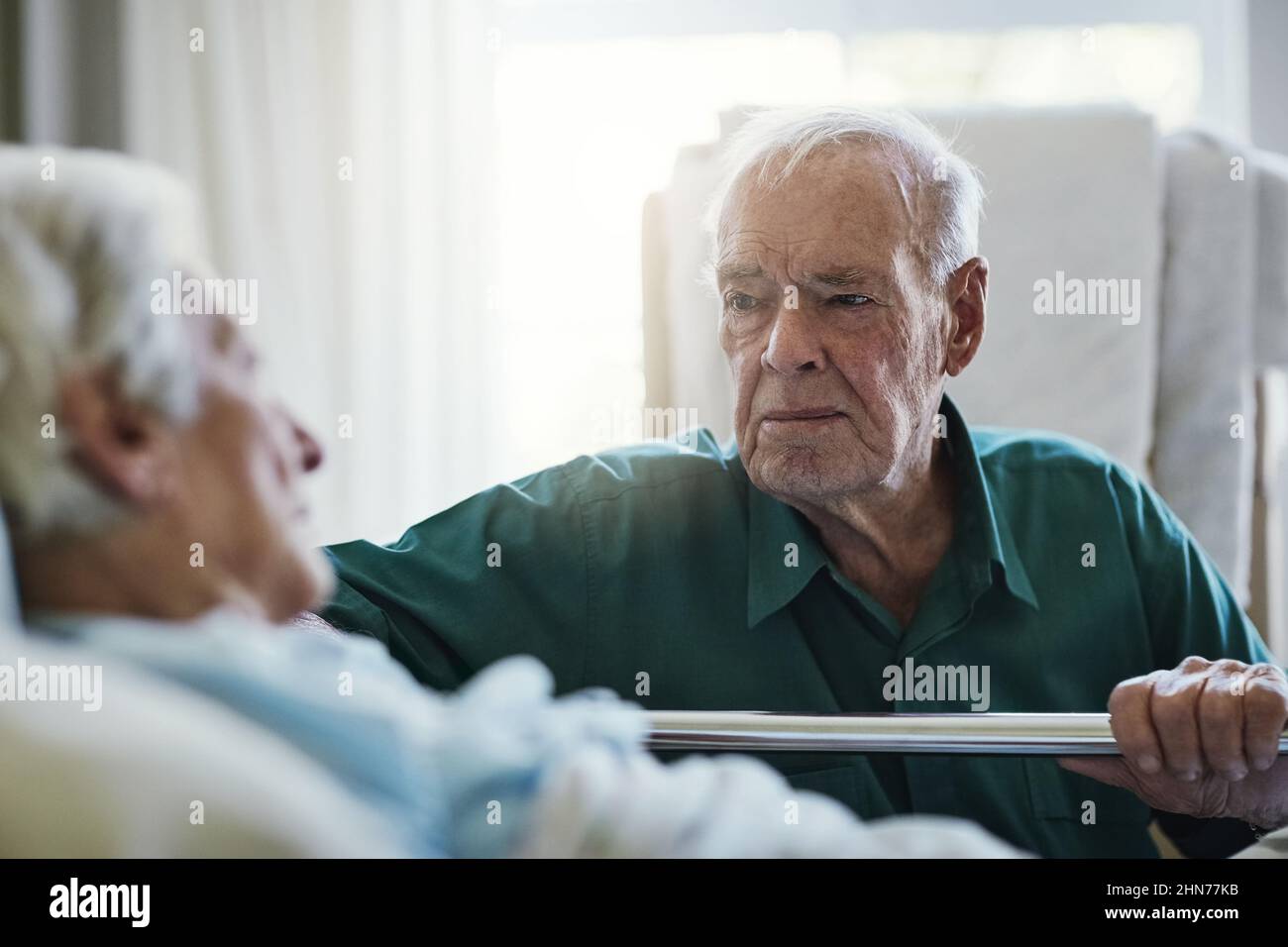 Malati essere sempre al vostro fianco. Shot di un uomo anziano che visita sua moglie in ospedale. Foto Stock