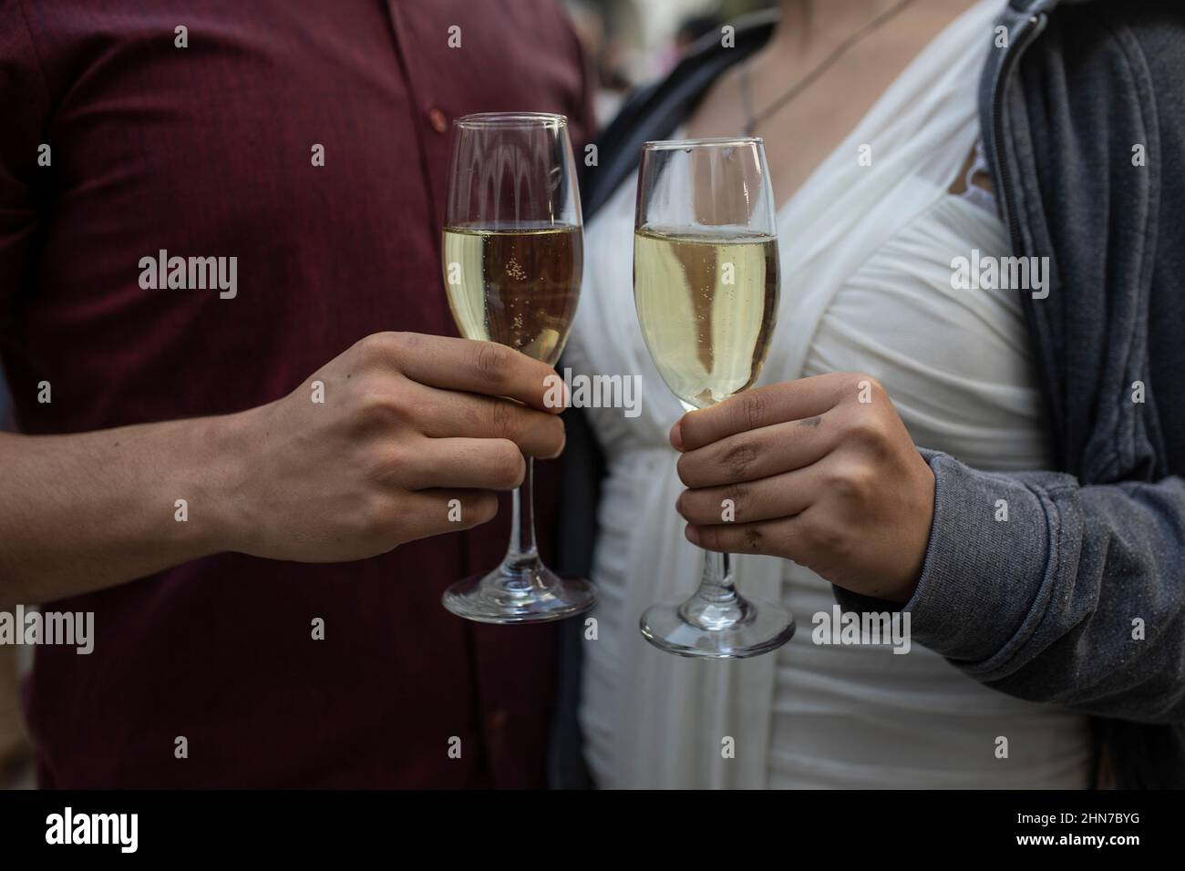 Veracruz, Messico. 14th Feb 2022. Una coppia si brinda con champagne dopo il matrimonio, che si è svolto in una data di San Valentino organizzata per diverse coppie dal municipio. Più di 300 coppie si erano registrate per questa data. Tuttavia, a causa delle restrizioni imposte dalla pandemia di Corona, sono state ammesse solo 20 coppie. Credit: Felix Marquez/dpa/Alamy Live News Foto Stock