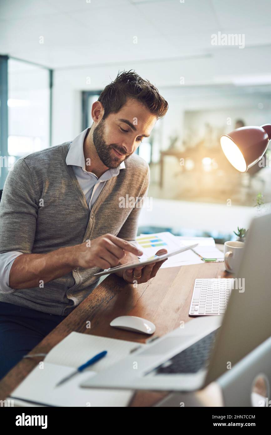 Egli rimane in cima al suo lavoro. Scatto corto di un uomo d'affari che lavora nel suo ufficio. Foto Stock