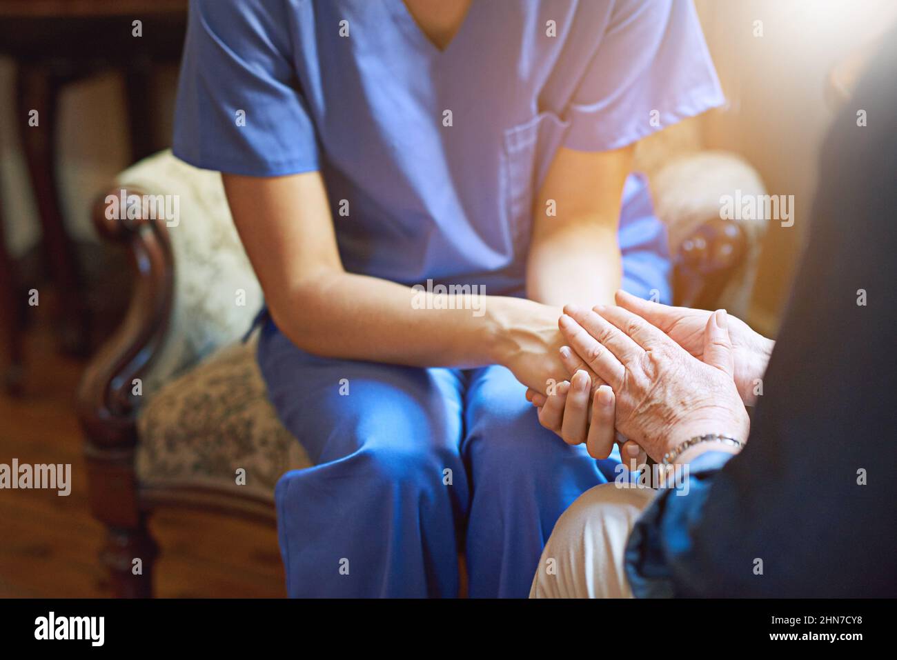 Si impegna per il comfort e la cura. Colpo di un residente che è consolato da un'infermiera in una casa di riposo. Foto Stock