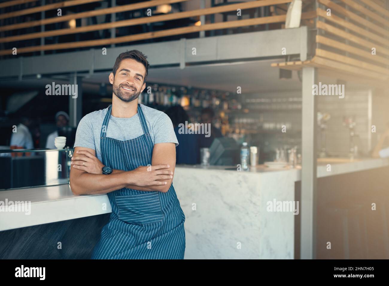 Come posso realizzare i vostri sogni di caffè. Ritratto di un giovane che lavora in un bar. Foto Stock