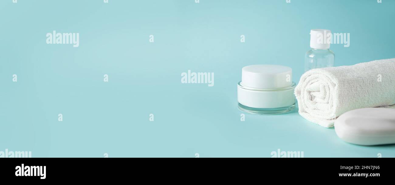 Prodotti cosmetici e accessori spa su sfondo blu. Crema, sapone e asciugamano. Cura della pelle, concetto di benessere. Spazio di copia, formato intestazione Foto Stock