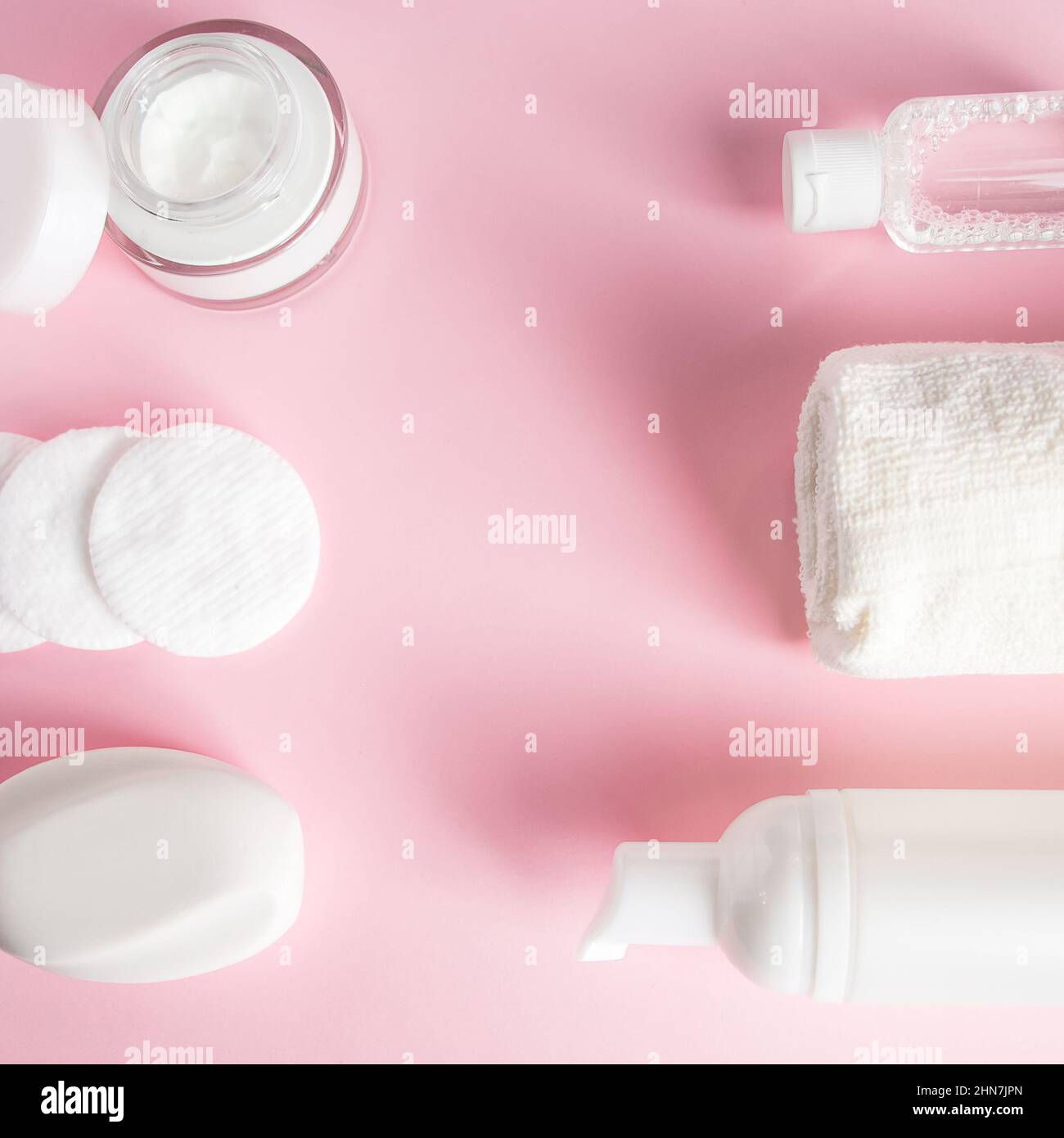 Prodotti cosmetici su sfondo rosa. Sapone, lozione e tamponi di cotone. Accessori per il centro benessere. Concetto di benessere. Foto Stock