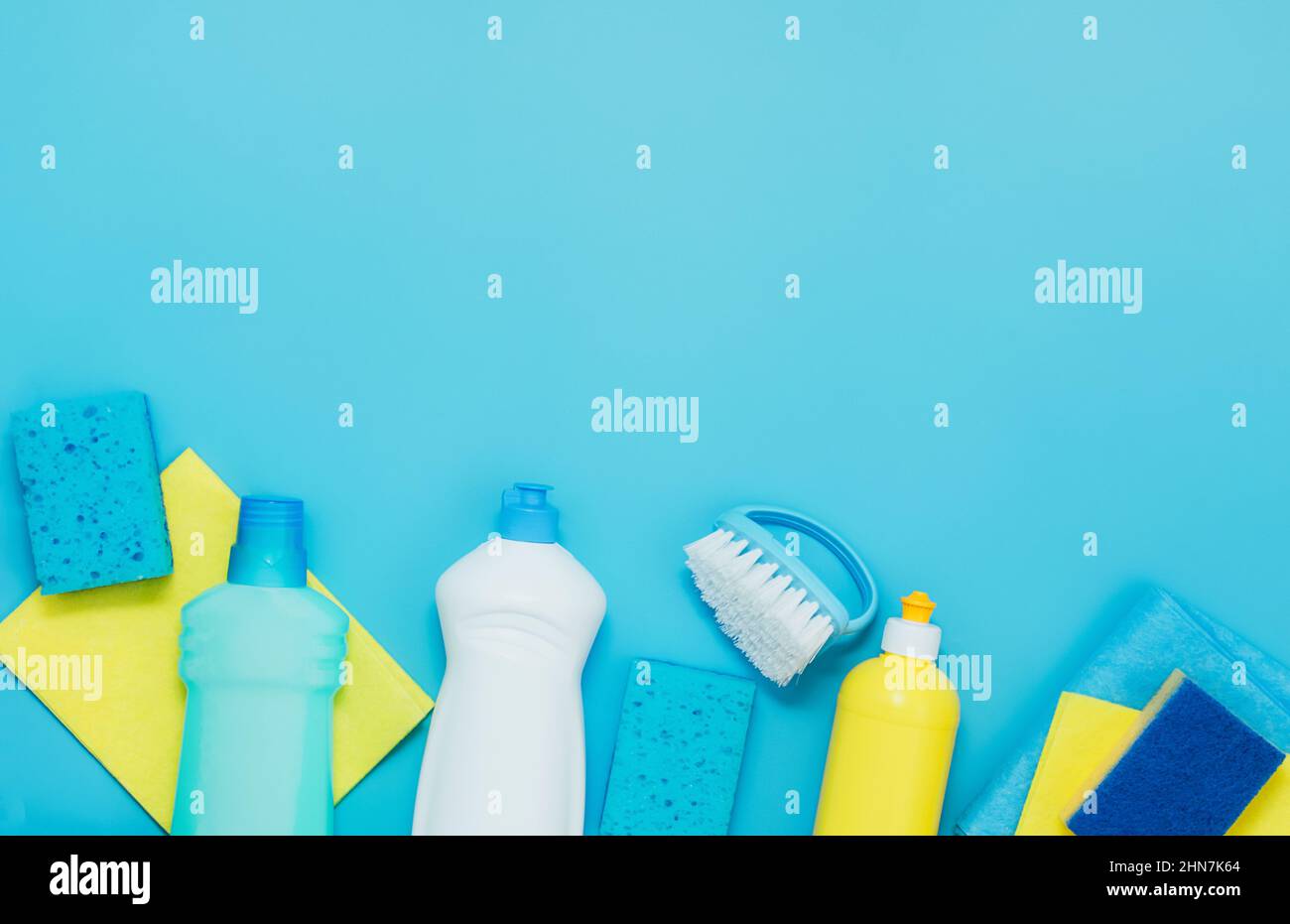 Kit pulizia detersivi tovaglioli spugne guanti, fondo blu. Il concetto di pulizia domestica o servizi aziendali di pulizia Foto Stock