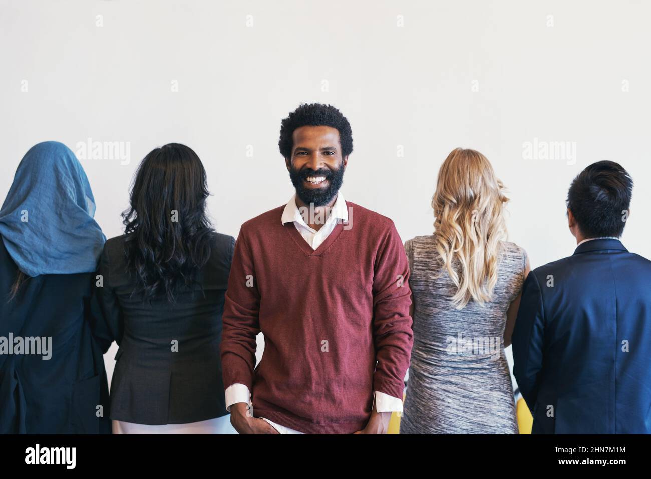 Non voltare mai le spalle su opportunità. Ritratto di un giovane uomo d'affari allegro in fila in attesa di un'intervista e il resto del Foto Stock