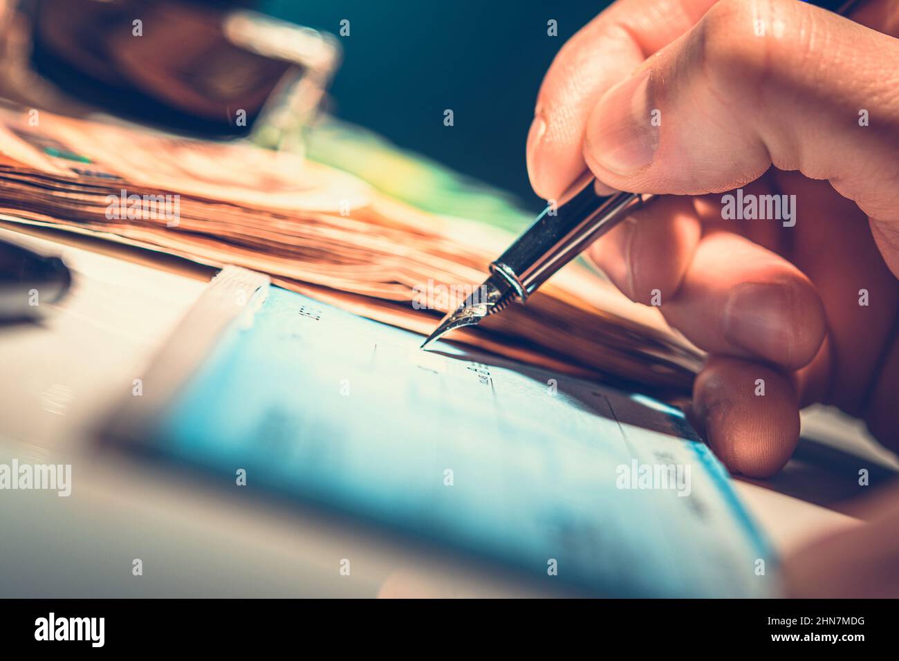 Preparazione di House Utilities Check Payments. Gli uomini caucasici che scrivono ancora un altro pagamento di assegno. Chiudi foto. Foto Stock