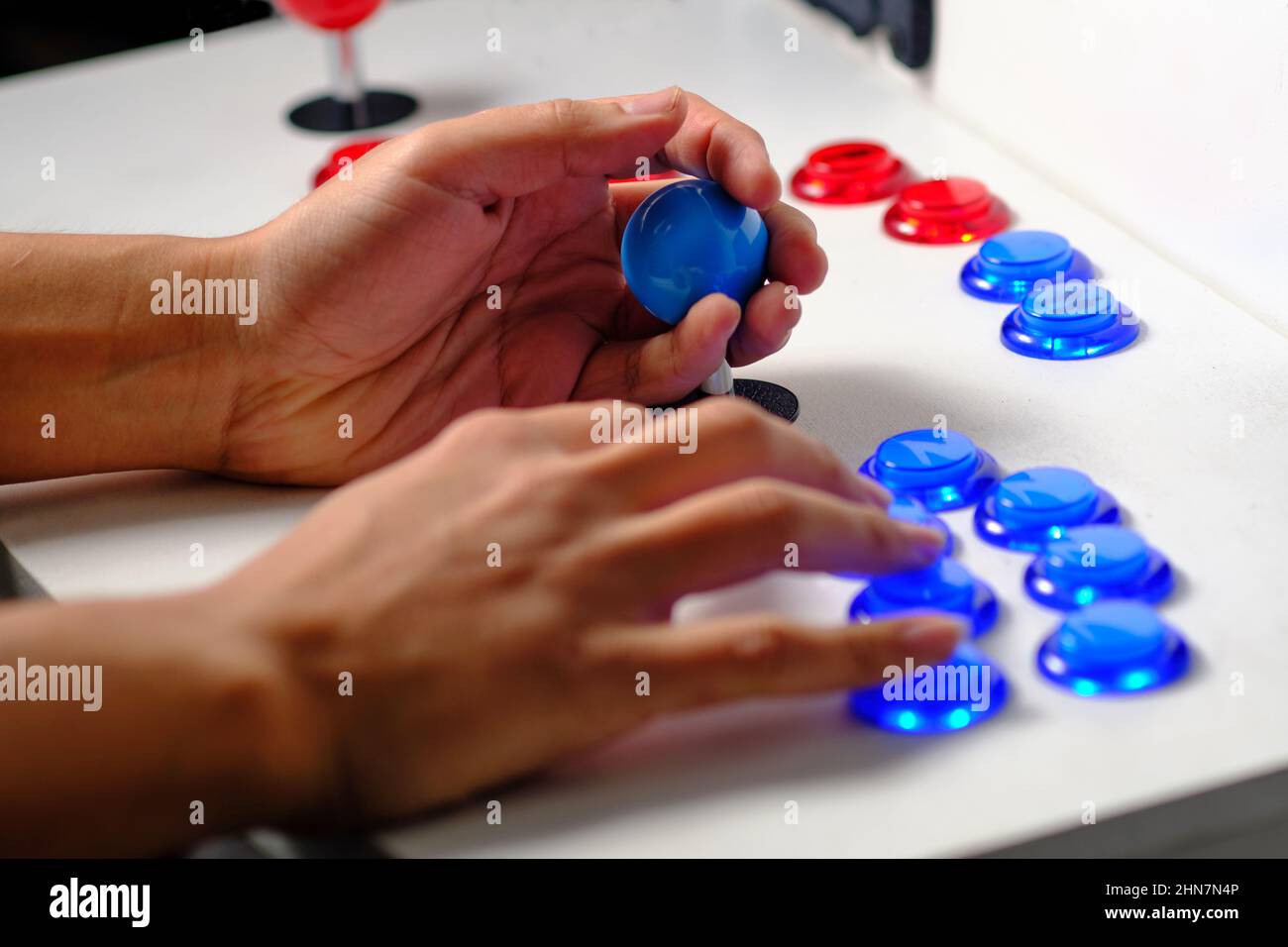 Dettaglio di mani con joystick arcade che gioca vecchio gioco arcade video Foto Stock