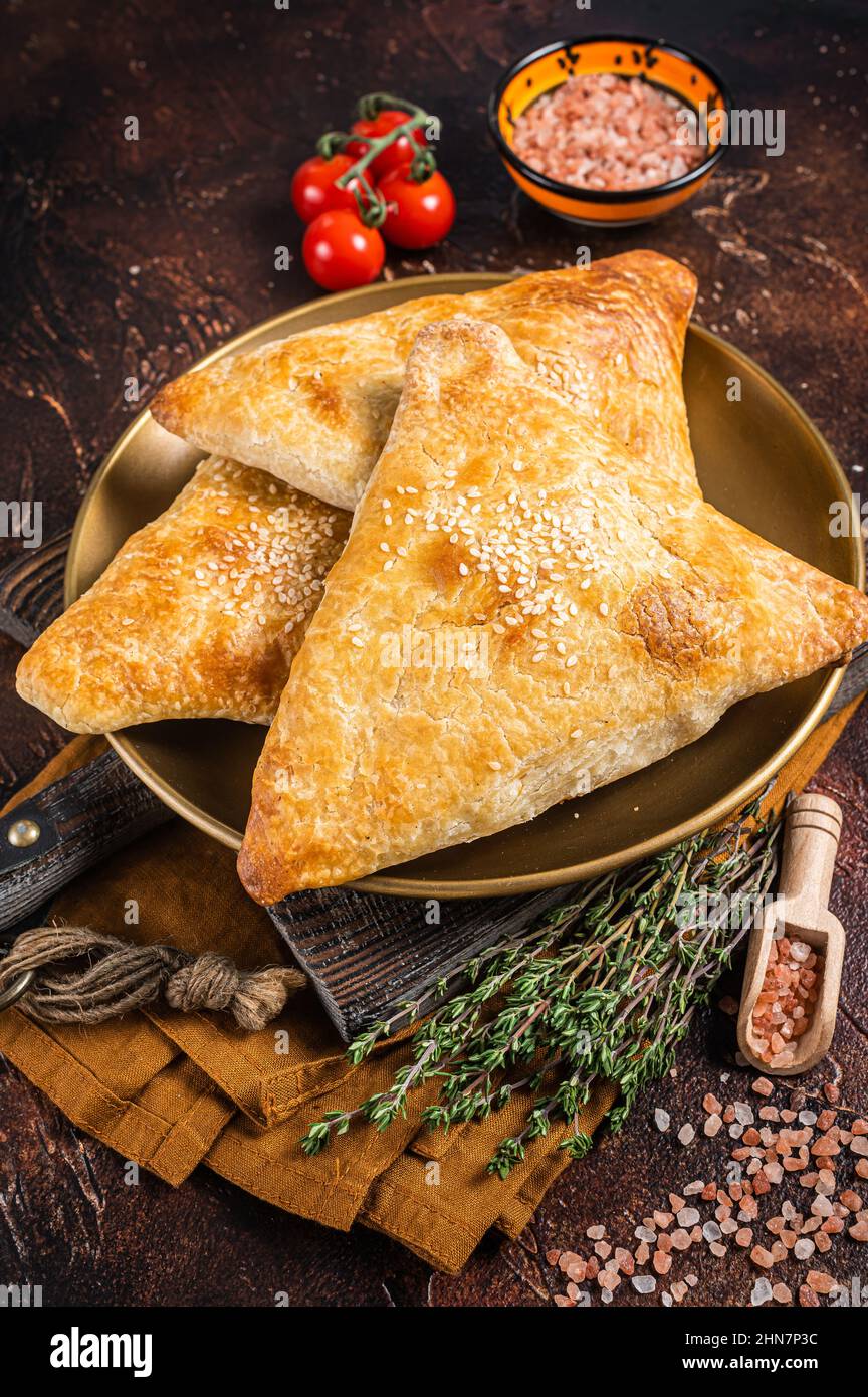 Samsa con pollo e formaggio, samosa torte orientali. Sfondo scuro. Vista dall'alto Foto Stock