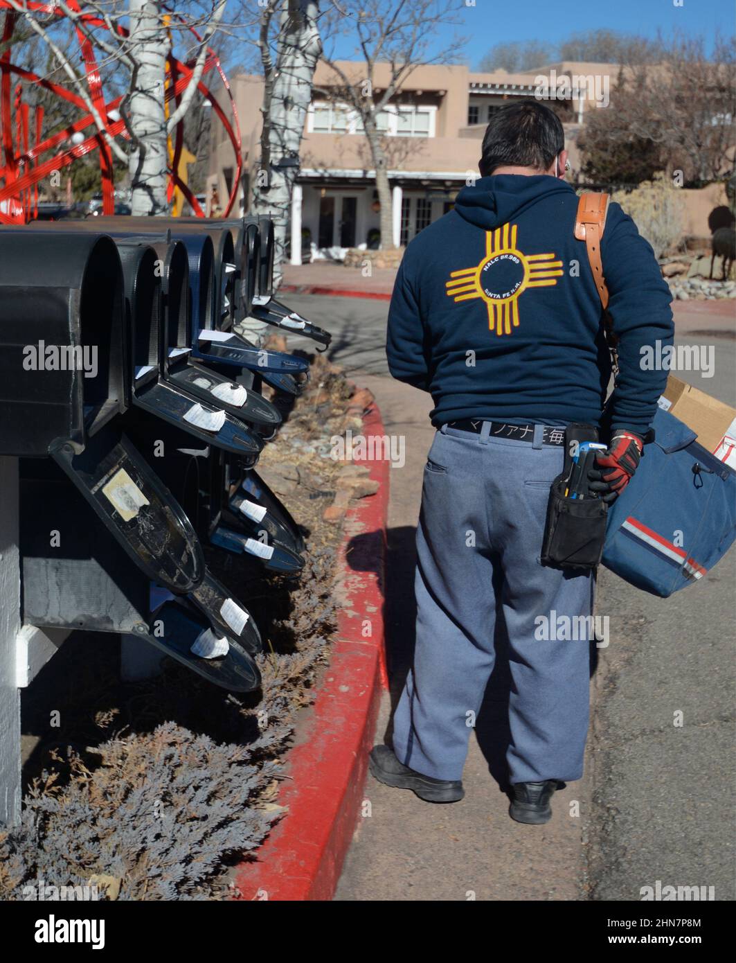 Un mailman americano o un corriere di lettere consegna la posta ad una fila di caselle postali a Santa Fe, New Mexico. Foto Stock