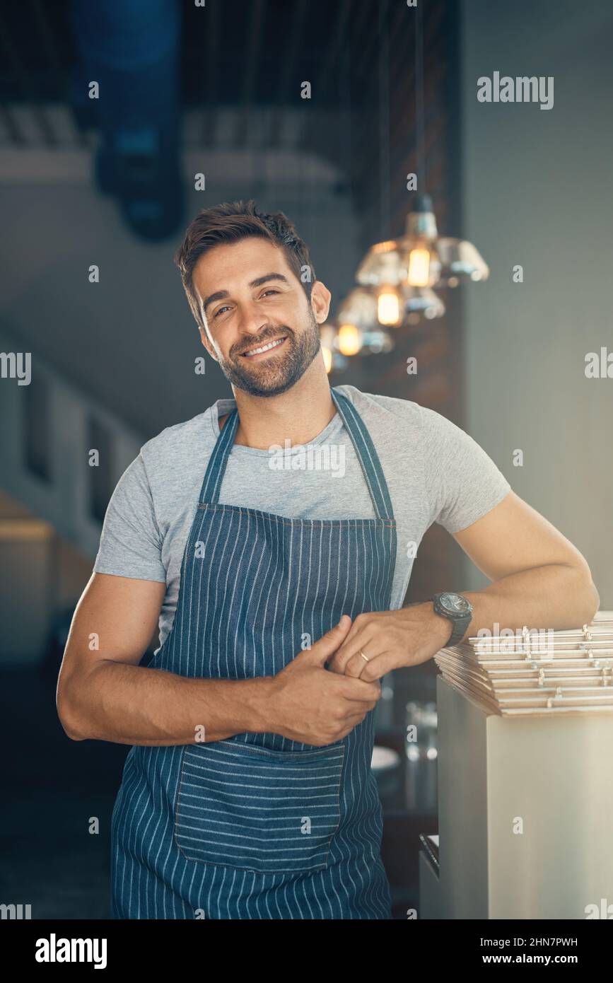Unisciti a noi per un caffè. Ritratto di un giovane che lavora in un bar. Foto Stock