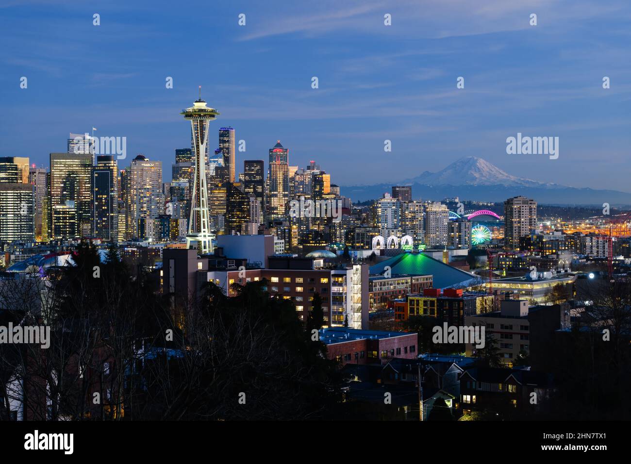 Seattle - 11 febbraio 2022; skyline della città di Seattle con il Monte Rainier mentre le luci si accendono durante una serata invernale Foto Stock
