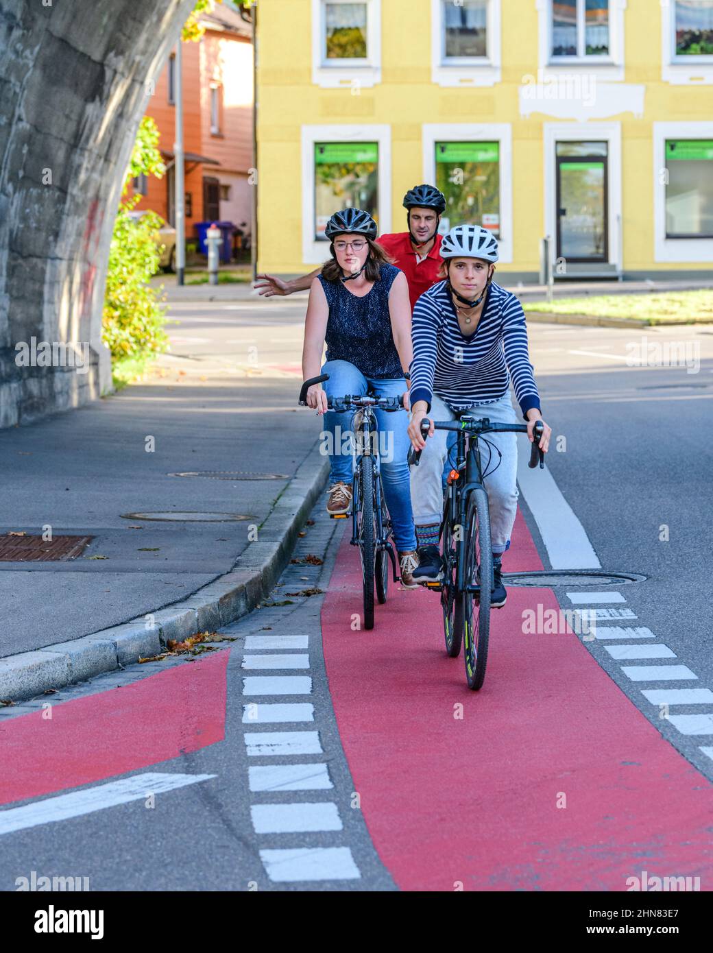 Ciclisti che utilizzano la strada ciclabile in zona urbana Foto Stock