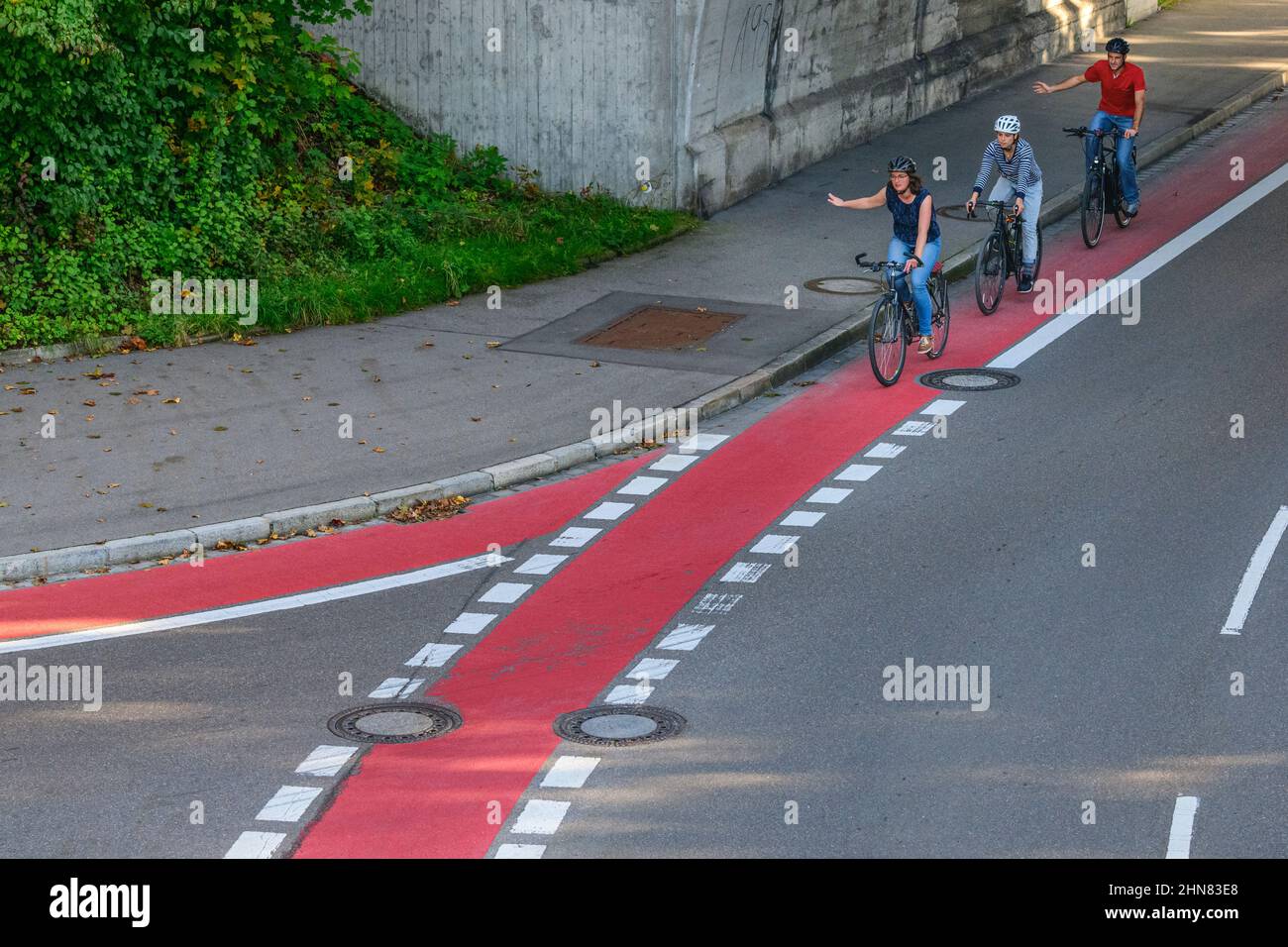 Ciclisti che utilizzano la strada ciclabile in zona urbana Foto Stock