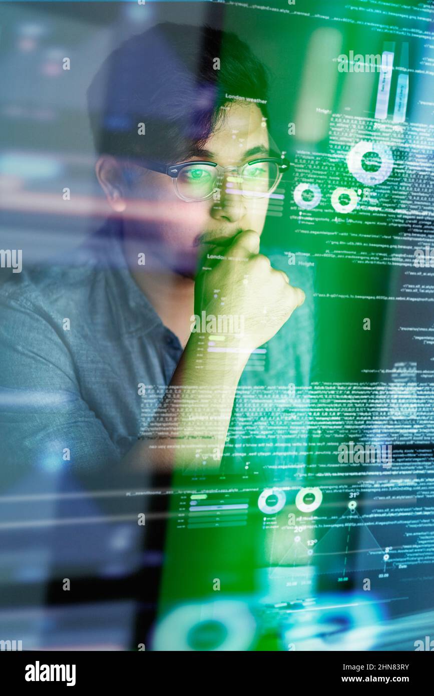 Mettendo un sacco di pensiero nel suo codice. Scatto ritagliato di un giovane programmatore di computer che guarda attraverso i dati. Foto Stock
