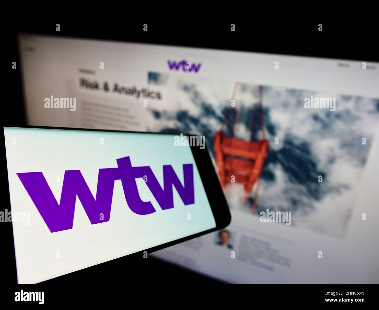 Cellulare con logo della società finanziaria Willis Towers Watson plc (WTW) sullo schermo di fronte al sito web aziendale. Mettere a fuoco sulla sinistra del display del telefono. Foto Stock