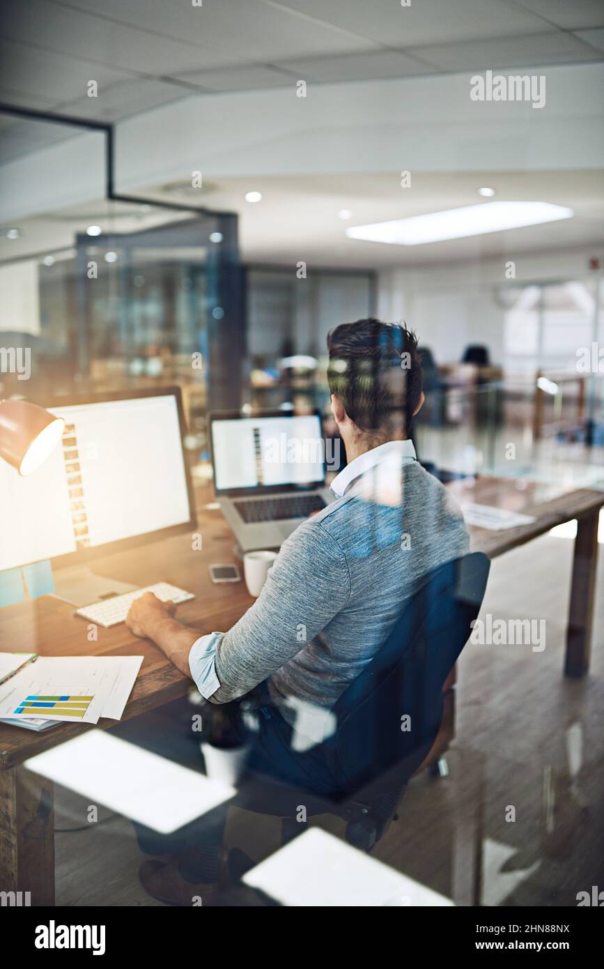 Egli rimane in cima al suo lavoro. Scatto corto di un uomo d'affari che lavora nel suo ufficio. Foto Stock