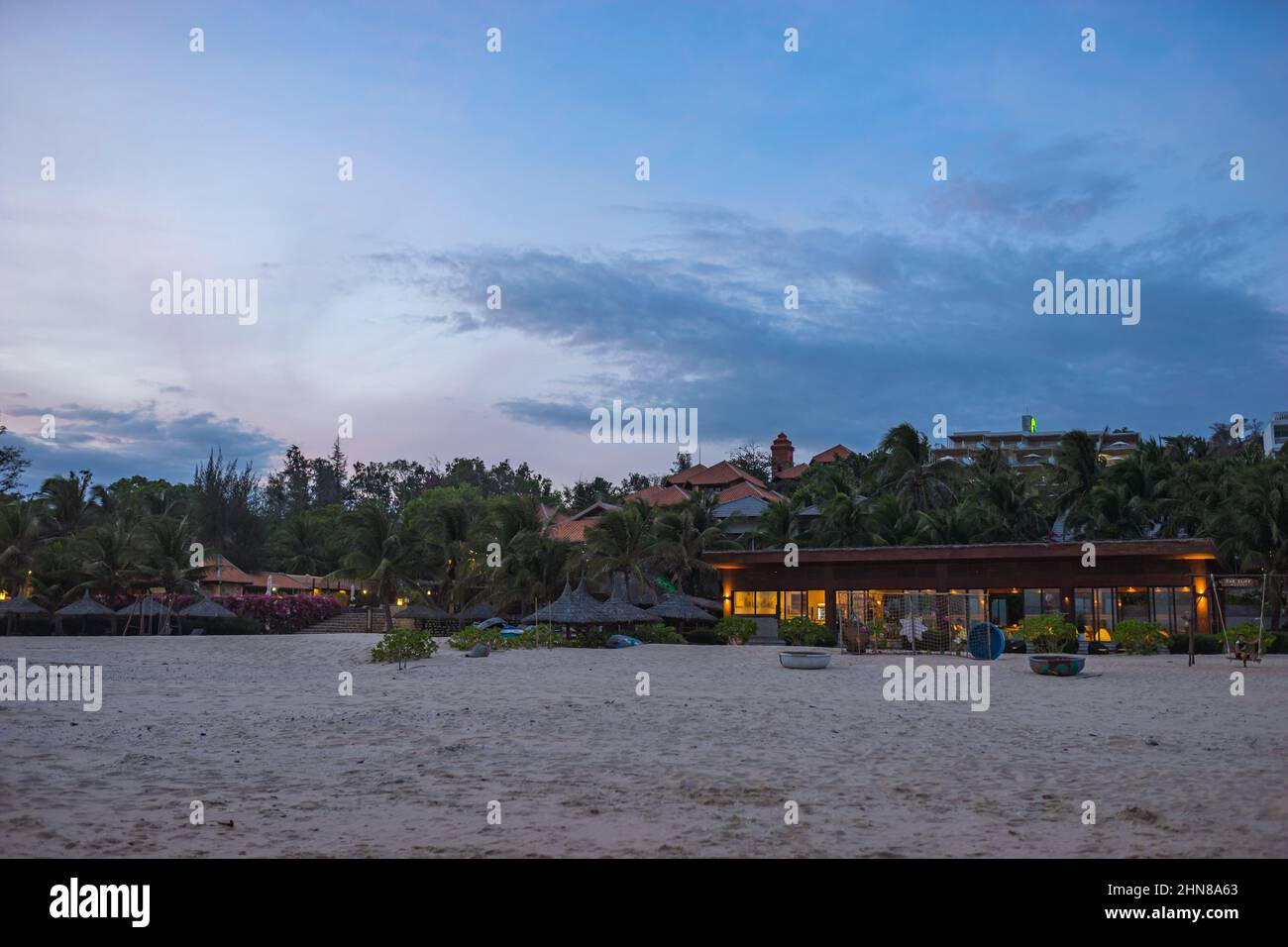 Vista panoramica dell'hotel ecologico sul mare. Hotel bellissimo sulla spiaggia, fine settimana sul mare. Palme al tramonto. Foto di alta qualità Foto Stock