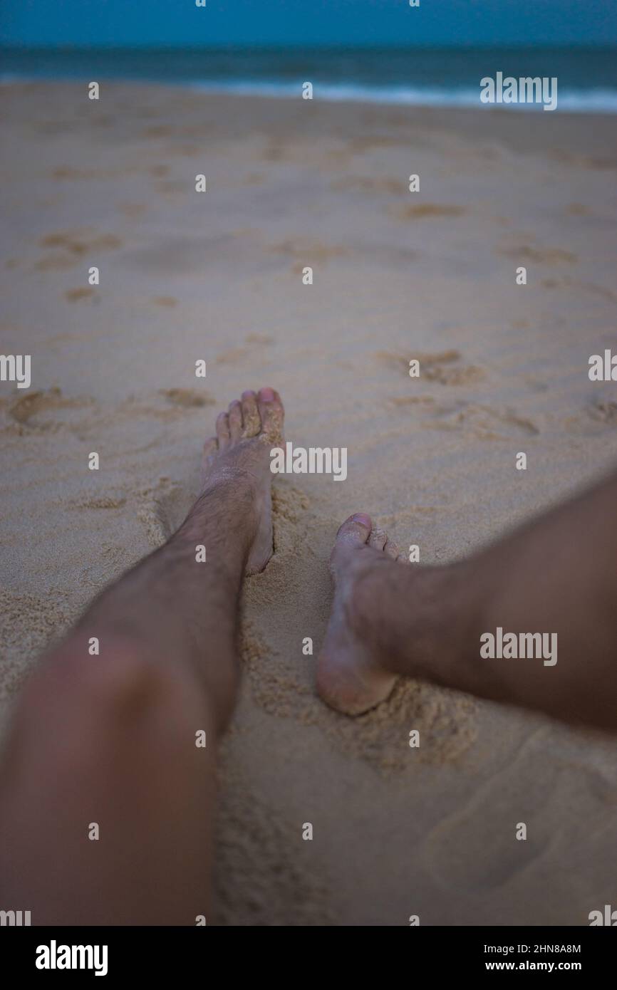 Uomini piedi sulla sabbia alla spiaggia, relax e relax sulla spiaggia, vacanze, vacanza sulla spiaggia. Gambe maschi. Foto di alta qualità Foto Stock