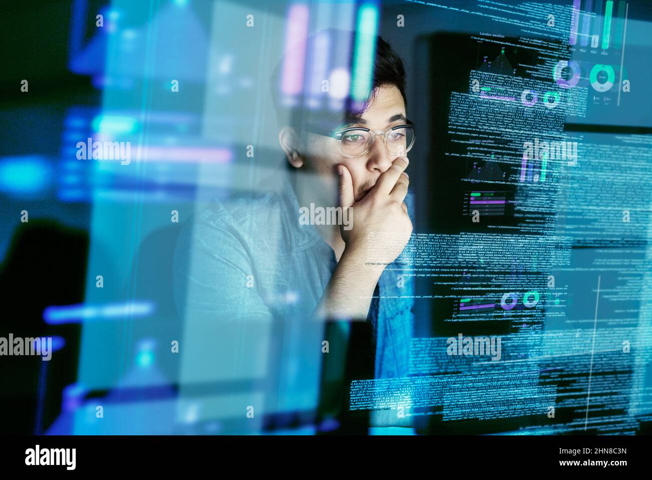 Ricerca di bug nel codice. Scatto ritagliato di un giovane programmatore di computer che guarda attraverso i dati. Foto Stock