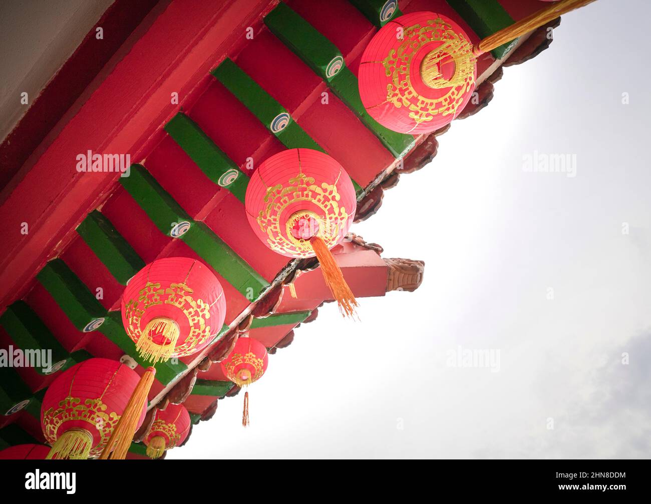 Lanterne rosse appese sul tetto del tempio. Vista ad angolo basso, spazio di copia. Foto Stock