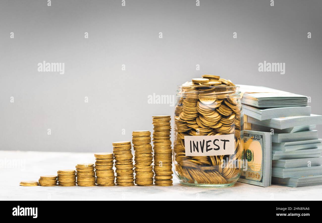 Vaso di vetro pieno di monete d'oro. Investimenti di risparmio. Foto Stock