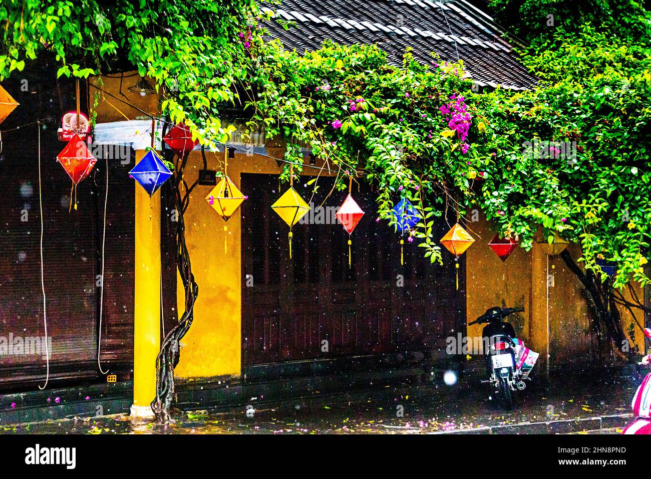 La parte anteriore del negozio è chiusa durante una pioggia intensa nella città vecchia, Hoi An. Foto Stock