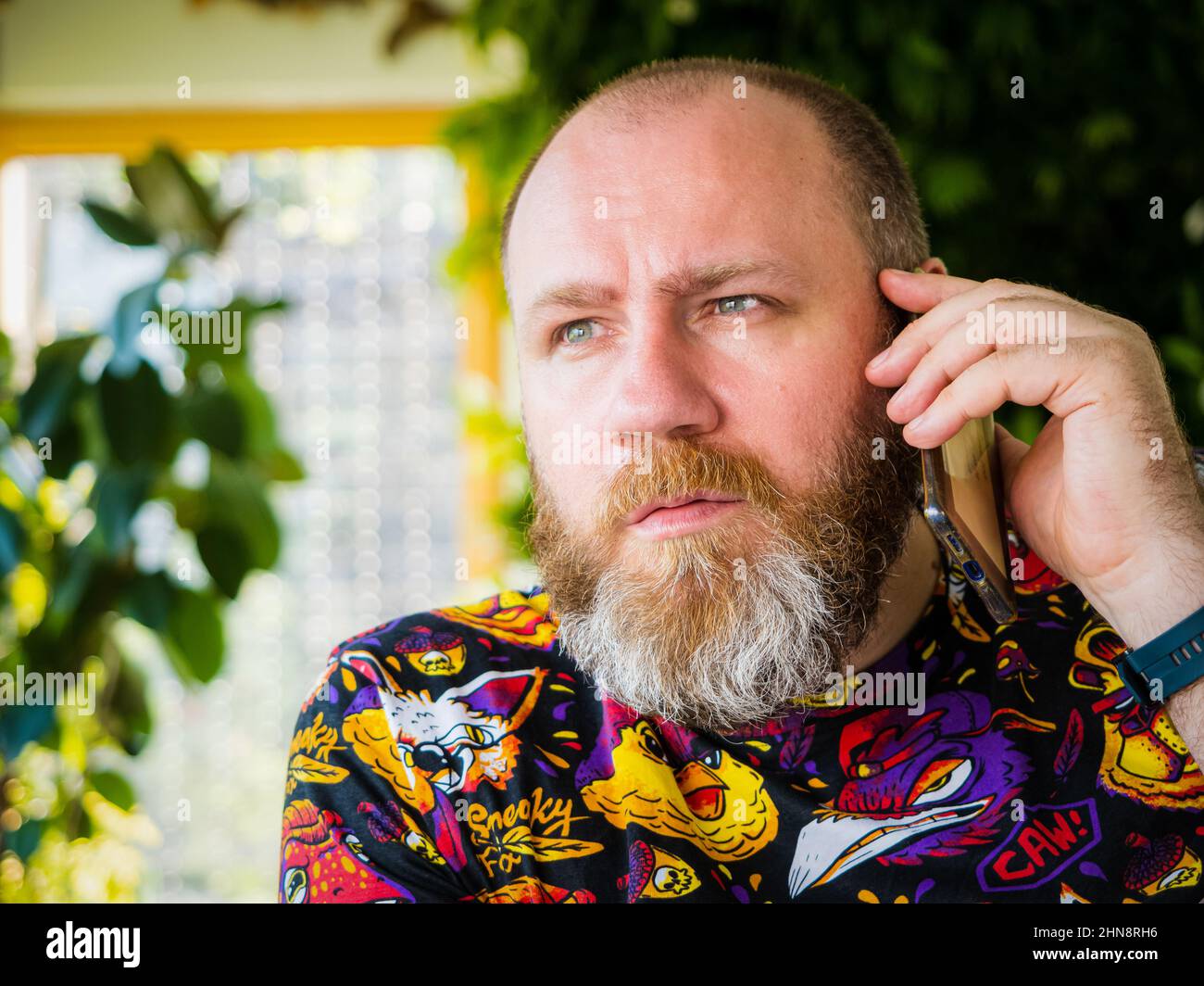 Candid foto di adulto preoccupato barbuto uomo parlare da smartphone Foto Stock